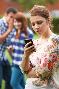 Teenagers cyberbullying another girl via her mobile phone