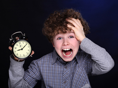 Boy holding alarm clock and realizing he's late for school