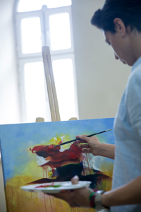 A GCSE age art student painting a picture