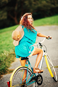 A happy teenage girl riding a bicycle