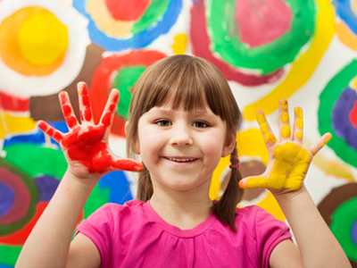 Young girl learning by playing with paint
