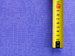 A yellow tape measure on a purple background