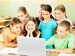 Elementary schoolchildren playing quiz on laptop