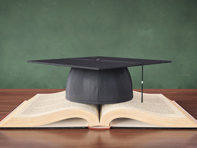 A mortarboard hat on top of an open book