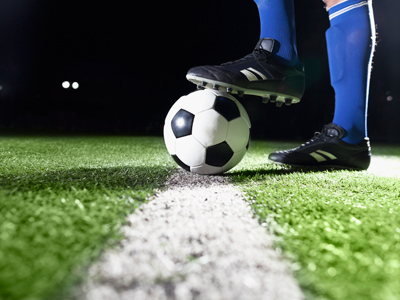 A footballer's boot about to kick a ball