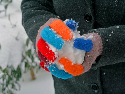 Woollen gloved hands holding a snowball