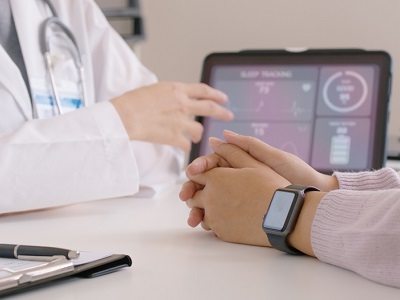 Photo showing a healthcare professional reviewing a digital heart monitor display with AI data analytics graphics overlaid, illustrating AI’s role in predicting patient health risks.