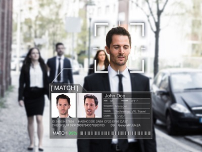 A man walking on a city street being scanned by facial recognition technology, showing a digital overlay with his profile details and a match result.