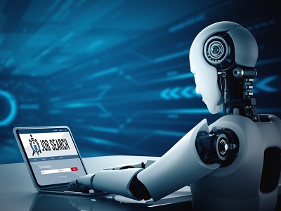 A humanoid robot sitting at a desk using a laptop that displays a job search page, representing artificial intelligence entering the workforce or exploring careers.