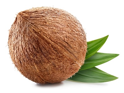 Whole brown coconut with textured shell resting on two green leaves on a white background.