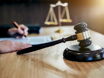 A close-up of a judge’s gavel beside legal papers and scales of justice, representing Apple’s courtroom request to dismiss Elon Musk’s xAI lawsuit over ChatGPT integration.