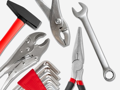 A variety of hand tools including a hammer, pliers, spanner, Allen keys, and grips laid out on a white background.