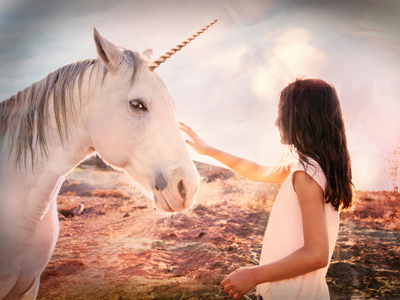 Woman stroking a unicorn with hazy background