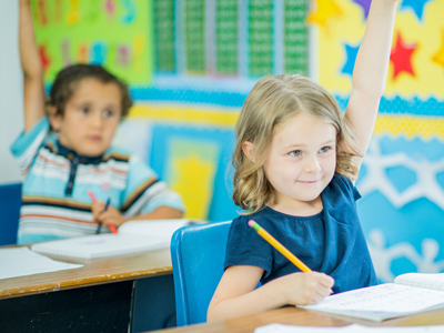 Girl in Grade 3 raising hand in class