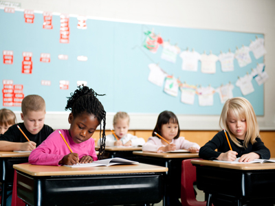 Grade 4 schoolchildren sitting at desks in classroom