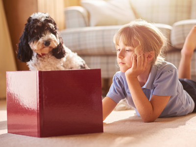 Girl and pet dog reading story book