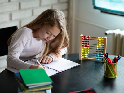 Schoolgirl doing homework with abacus