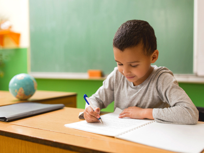 Boy writing a narrative in class