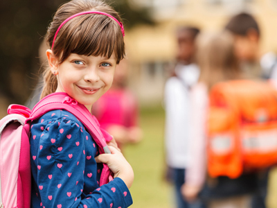 Schoolgirl with backpack looking at camera