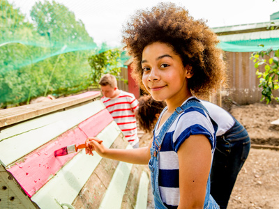 Volunteer painting chicken coop at a farm