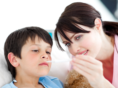 Child having temperature taken by nurse