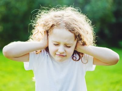 Child covering ears to shut out noise