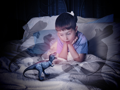 Child playing with toy dinosaur