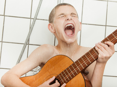 Child playing guitar and singing in shower