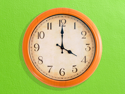 Orange clock showing 4:00 on green background