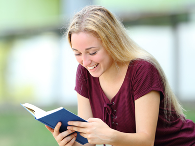 Happy teenage girl reading
