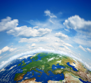 World globe with fluffy clouds above
