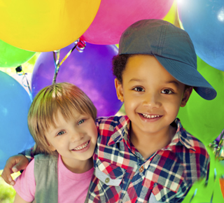 Two happy and healthy children surrounded by balloons