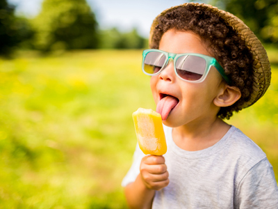 Boy in sunglasses licking an ice lolly