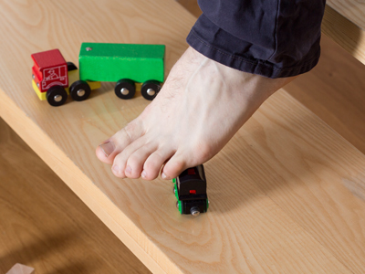 Child's foot treading on toy