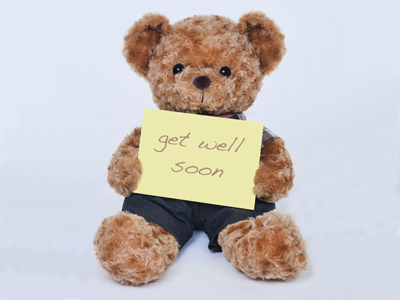 Teddy bear holding get well soon card