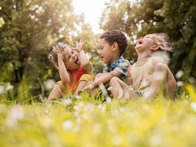 Happy children laughing sitting on grass