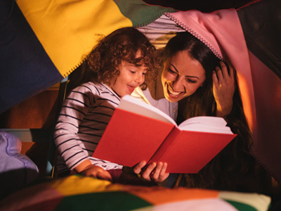 Mother and young child reading a book together