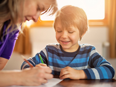Mother helping her young son with his homework