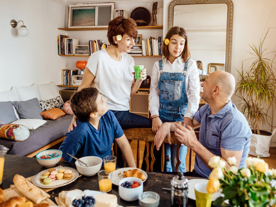 Happy children having breakfast with family before school