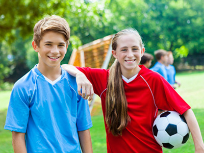 Boy and girl relaxing by playing football