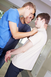 Two teenage boys bullying their friend