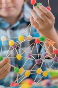 Kinaesthetic learner making model of molecule with sticks and sweets