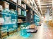 Autonomous warehouse robots navigating aisles using AI-powered path planning, with digital graphics showing sensors, data, and obstacle detection systems.