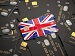 Close-up of many black bank cards with contactless symbols, topped by a single cards in the colours of the UK flag, suggesting British finance and payments.