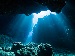 Underwater cave with light streaming through, representing the deep-sea environment where AI is now being used to explore volcanoes and ocean data.