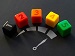 A row of five coloured dice numbered 1 to 5, placed above a printed speedometer graphic, symbolising progress or an upgrade.