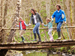 Young family crossing old wooden bridge