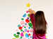 Child hanging decorations on wall