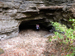 Girl hiking out of cave entrance