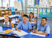 Smiling schooldchildren sitting at desks in class